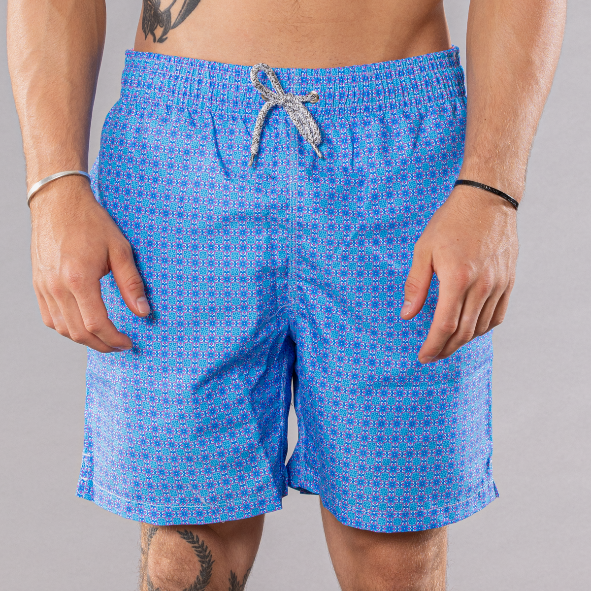 Men&#39;s blue/coral swim trunks with ethnic tile pattern, front view