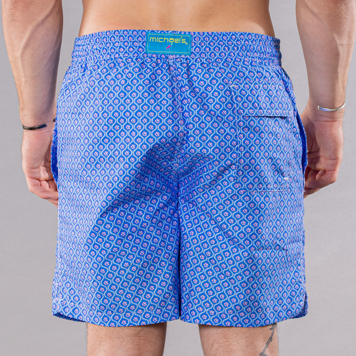 Men&#39;s blue/pink swim trunks with geo pattern, back view
