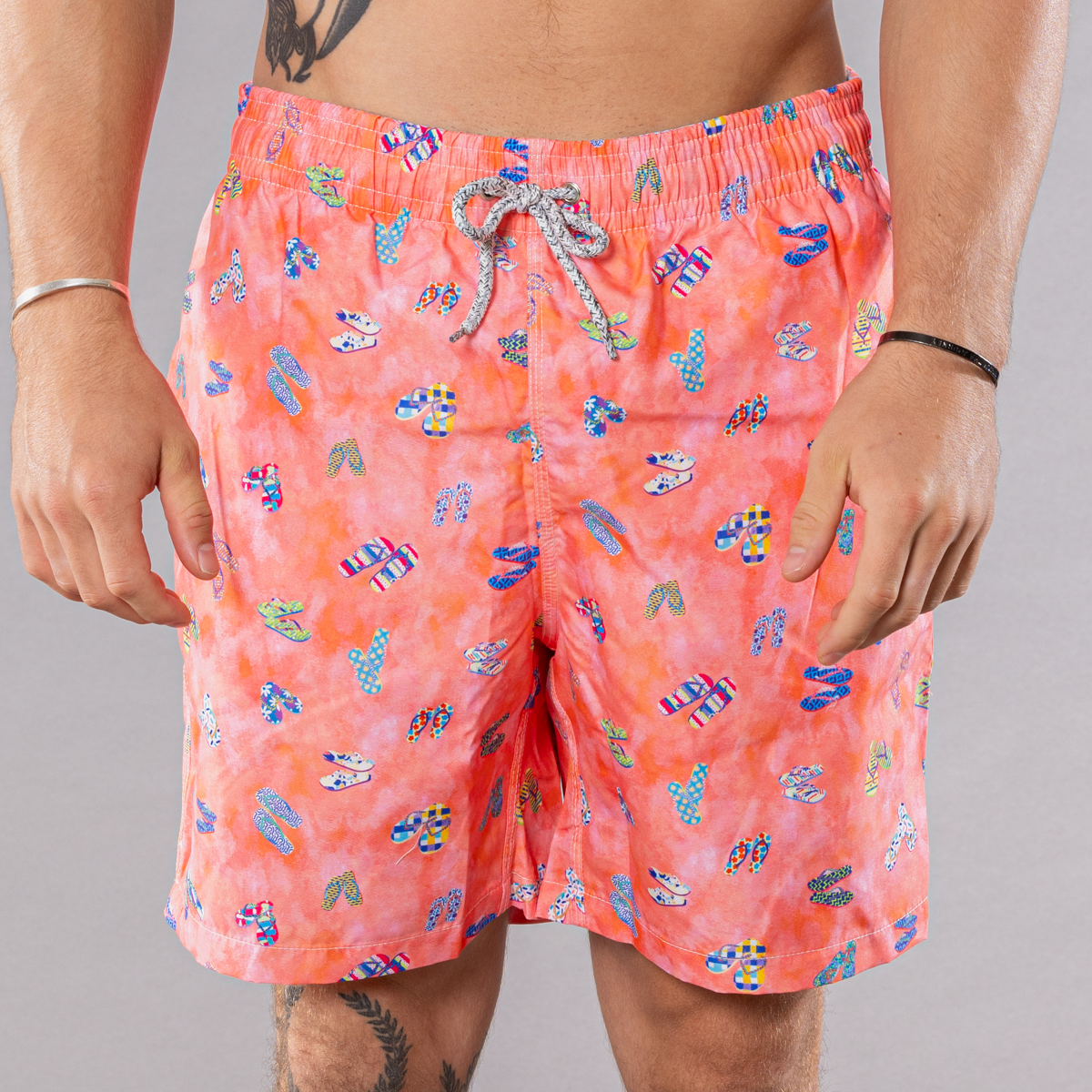 Men&#39;s coral swim trunks with flip flops pattern, front view