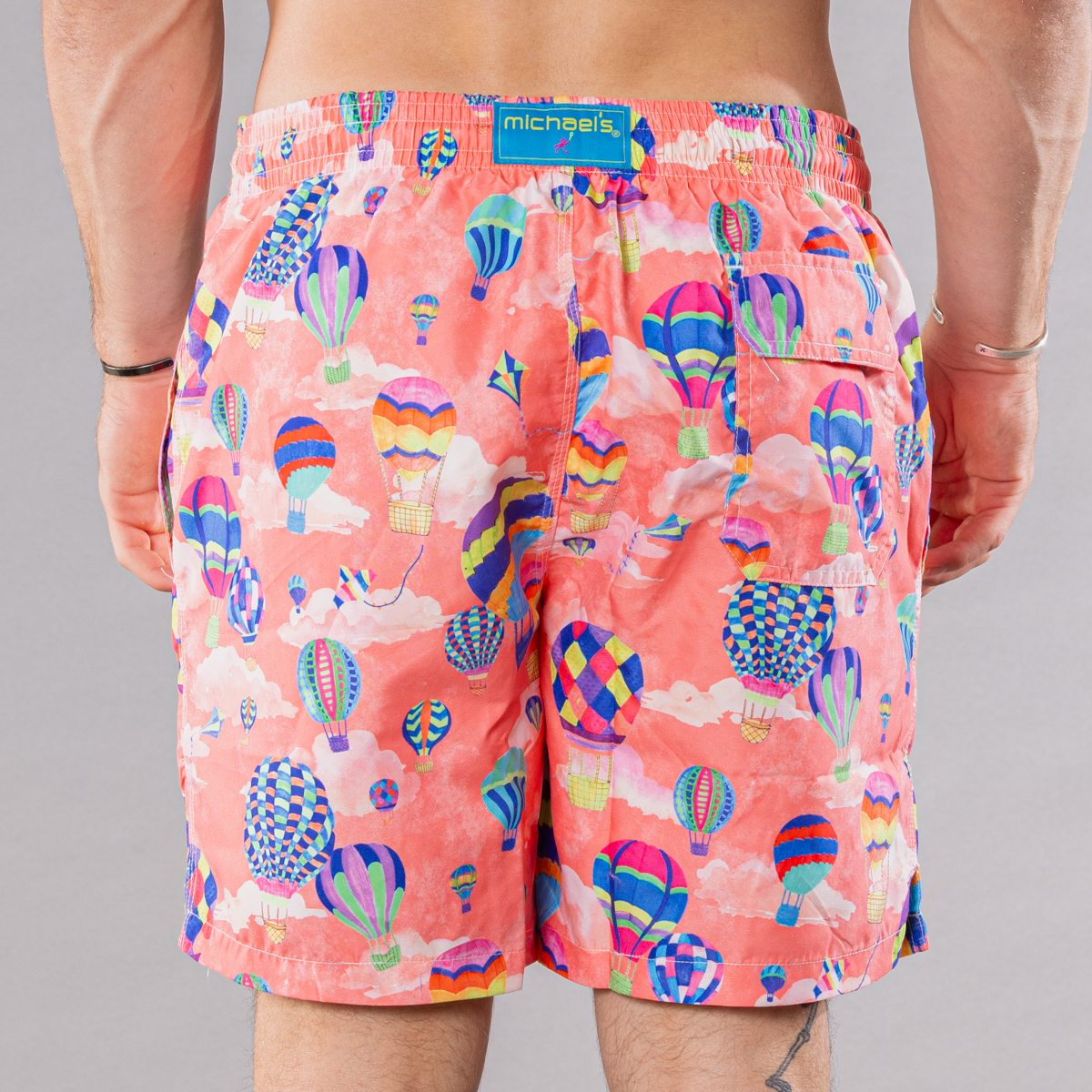 Men&#39;s coral swim trunks with hot air balloons pattern, back view