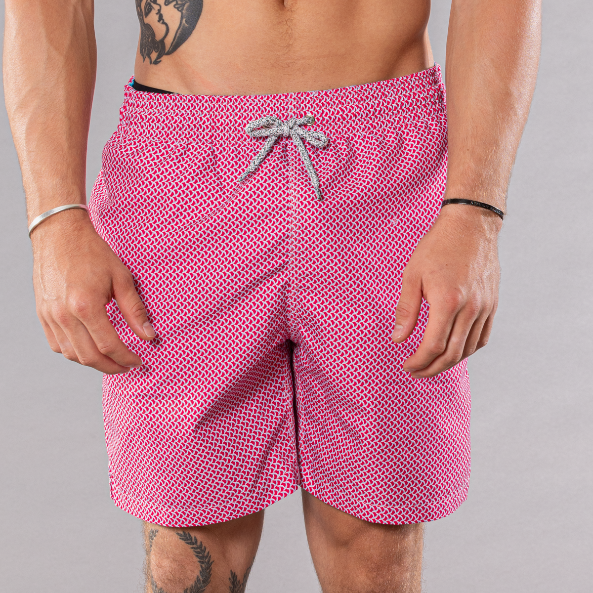 Men&#39;s coral/turquoise swim trunks with wave pattern, front view