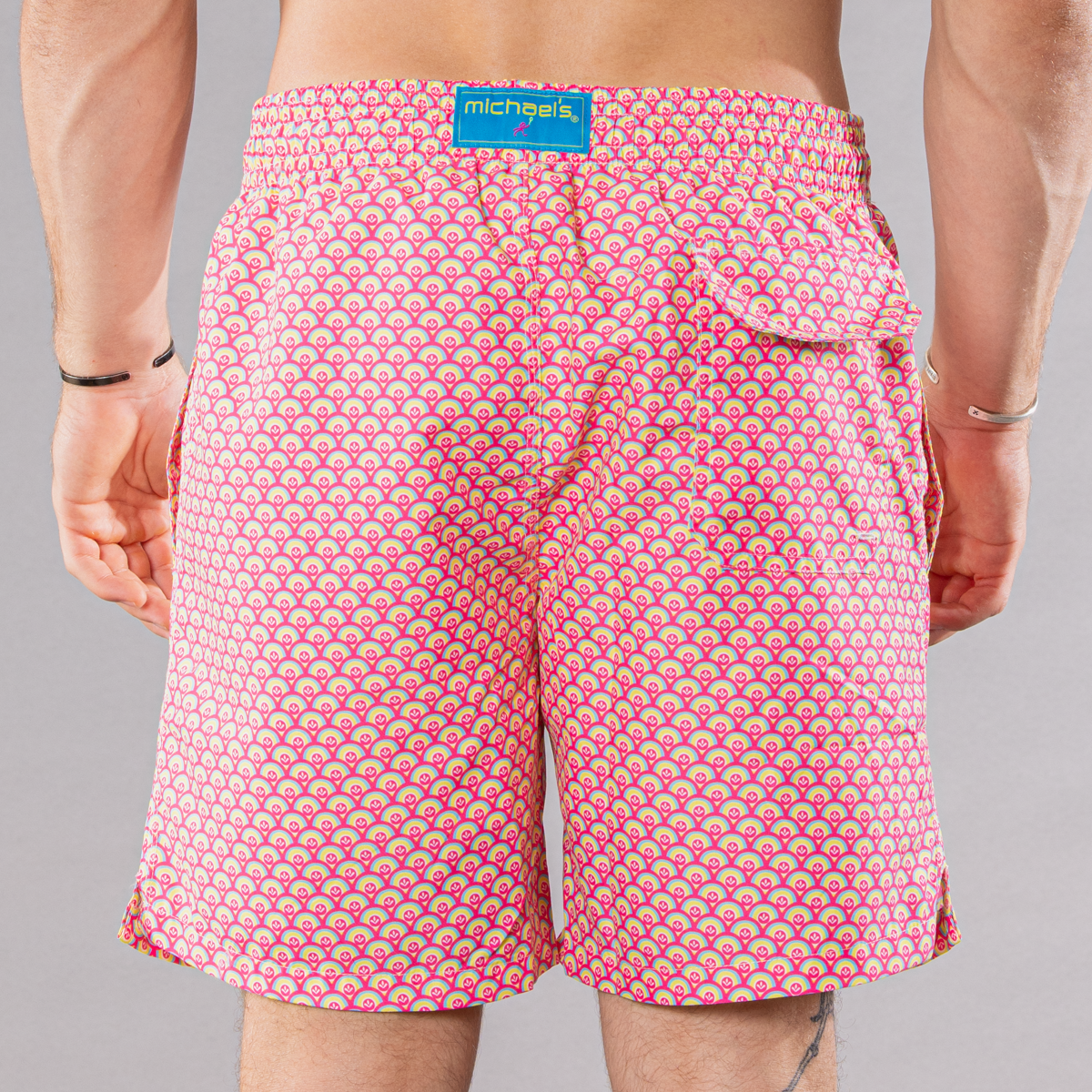 Men&#39;s coral/yellow swim trunks with cyclist liner, half moons pattern, back view