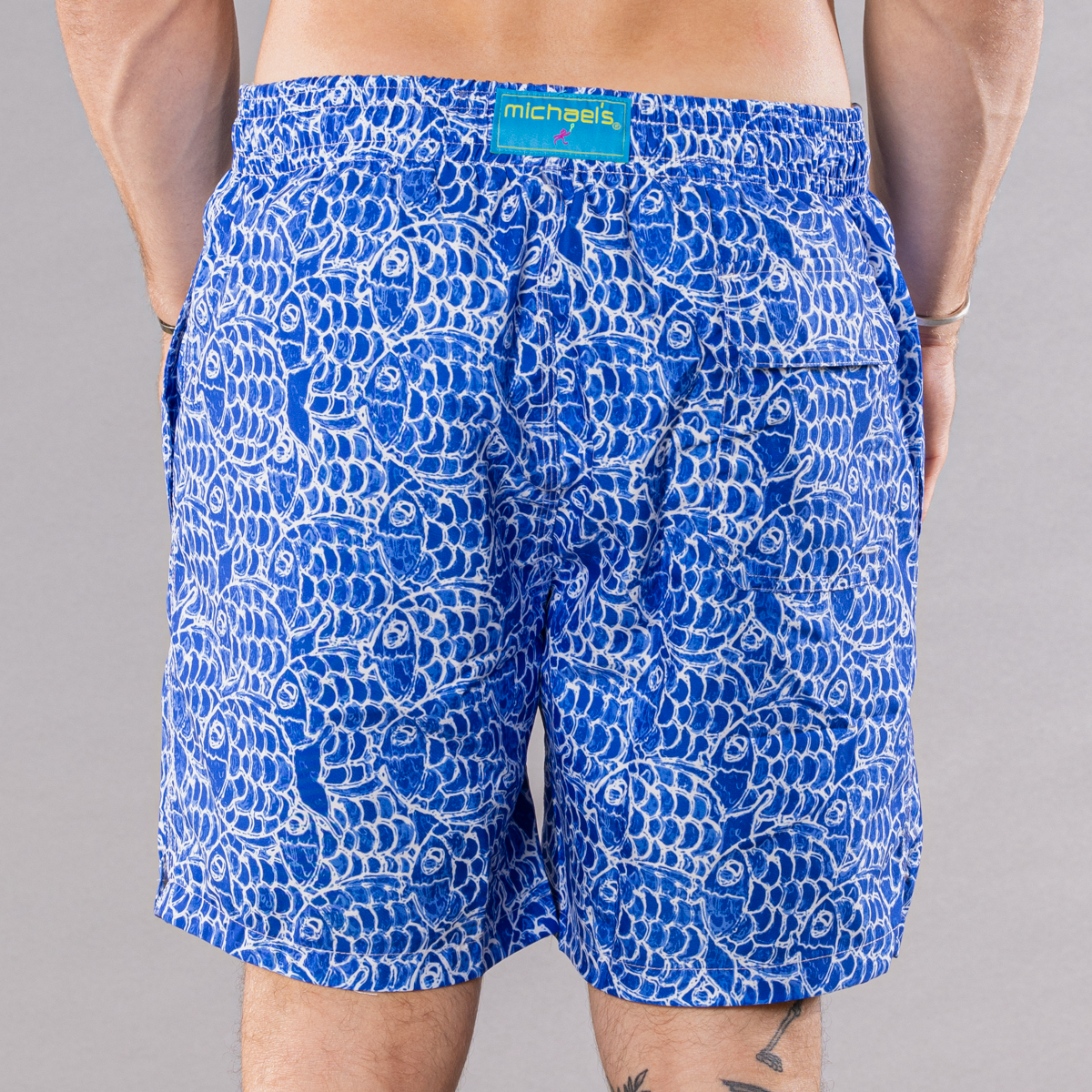 Men&#39;s navy swim trunks with abstract fish pattern, back view
