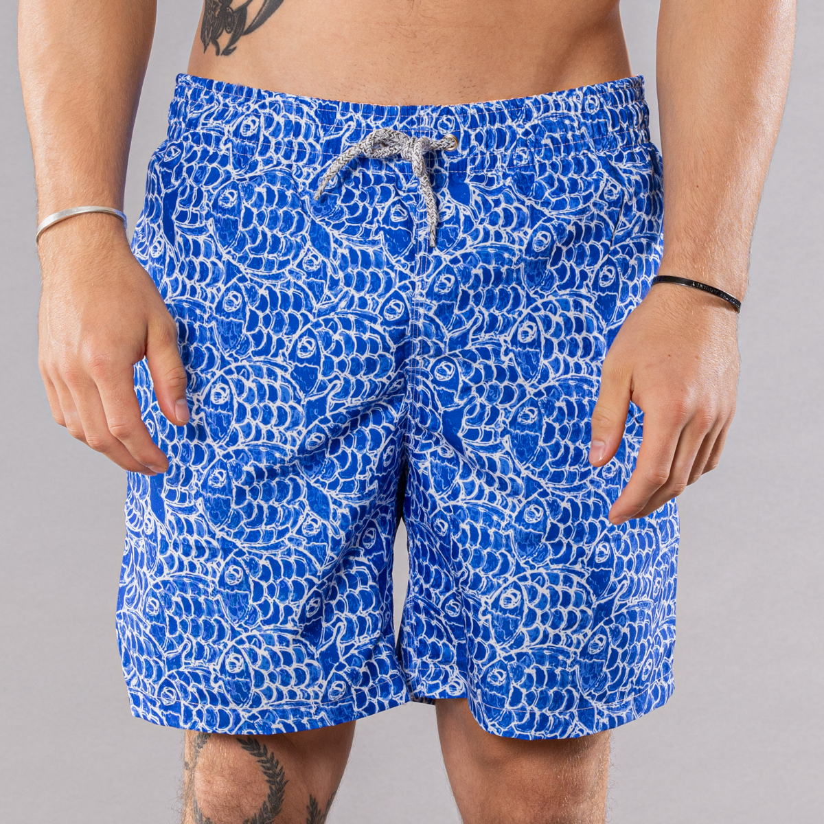 Men&#39;s navy swim trunks with abstract fish pattern, front view