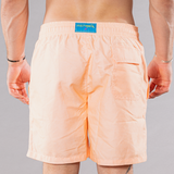 Men's solid print swim trunks in orange, back view